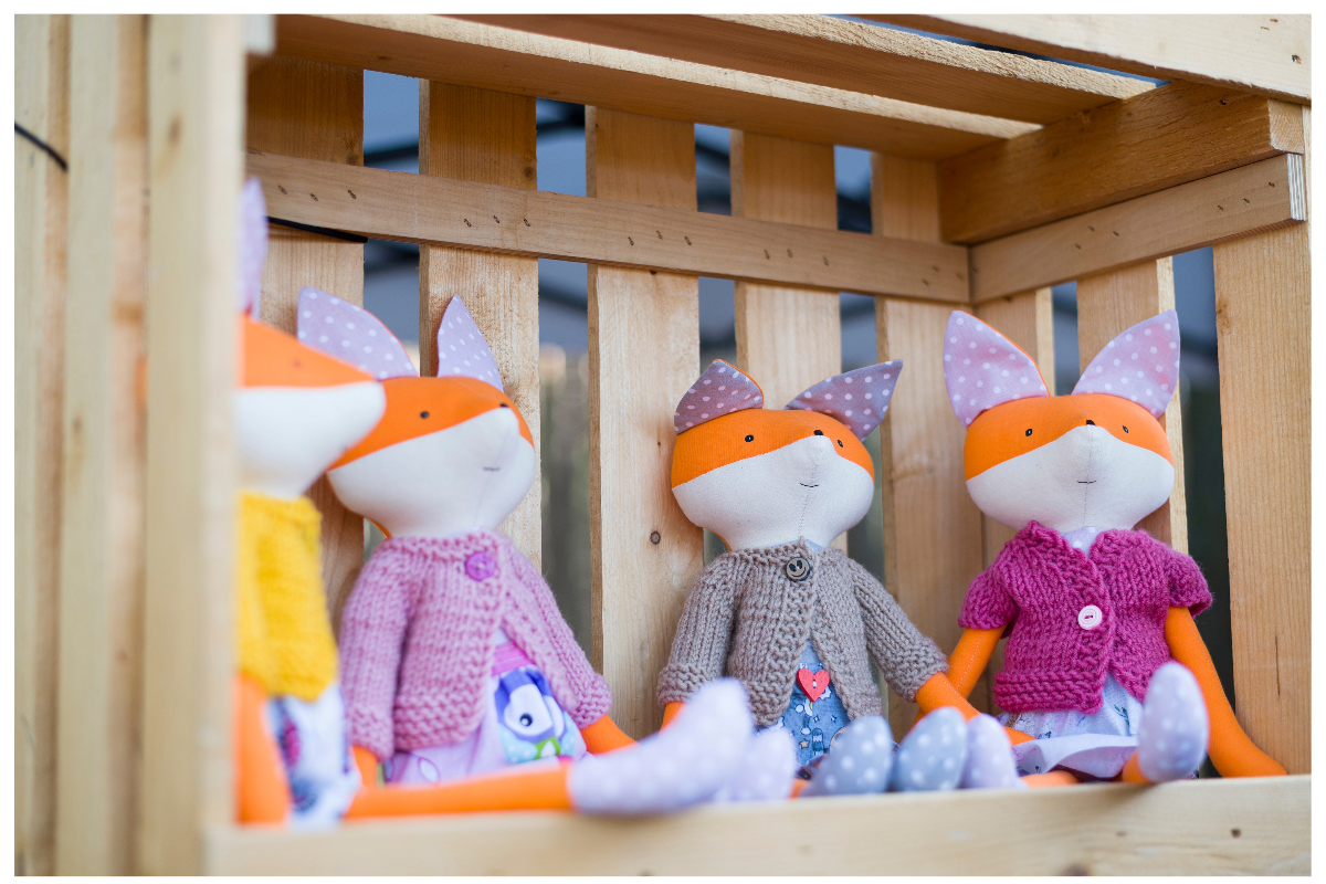 A group of stuffed animals in a wooden box

Description automatically generated